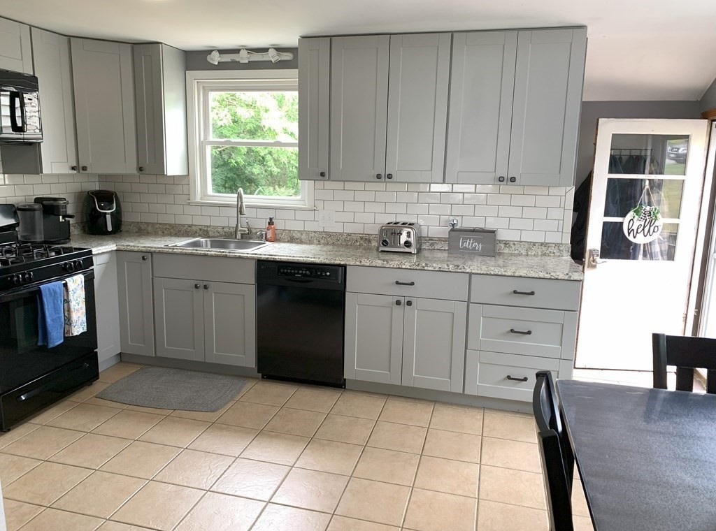 12 Garnet Road Billerica, MA 01821 - Photo 3 of 12 a kitchen with a stove a sink a window and cabinets