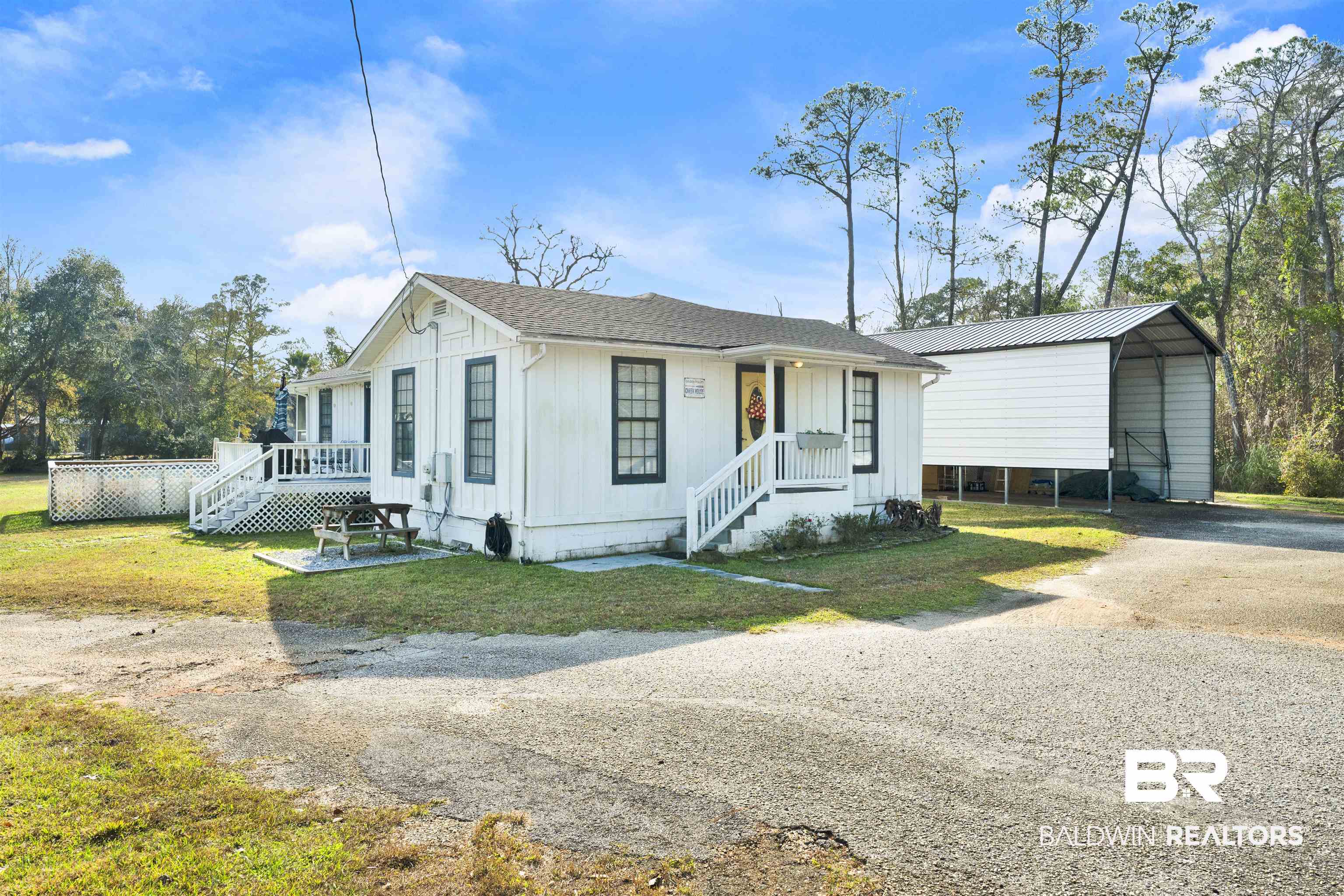 23770 Miflin Road Elberta, AL 36530 - Photo 2 of 38 View of front of house with driveway, a carport, board and batten siding, and a front yard