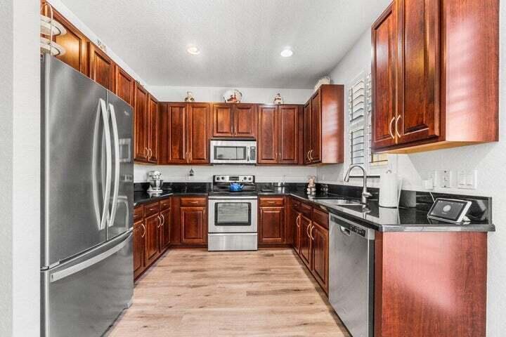 207 Edenberry Avenue Jupiter, FL 33458 - Photo 3 of 16 a kitchen with stainless steel appliances granite countertop a stove a sink dishwasher a refrigerator and cabinets with wooden floor
