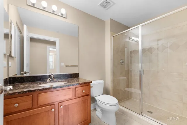 a bathroom with a granite countertop sink toilet and shower