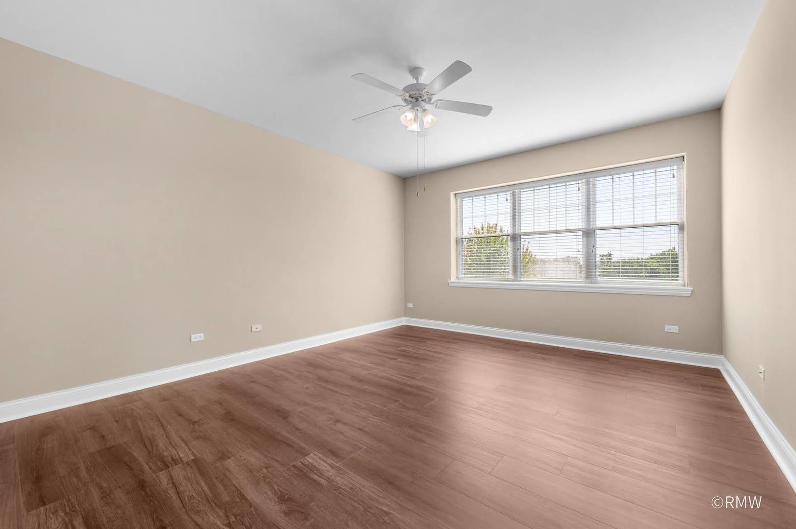 2 Itasca Place, Unit 420 Addison, IL 60143 - Photo 15 of 20 an empty room with wooden floor windows and fan