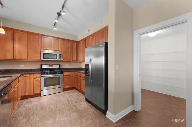 a kitchen with granite countertop stainless steel appliances and wooden cabinets