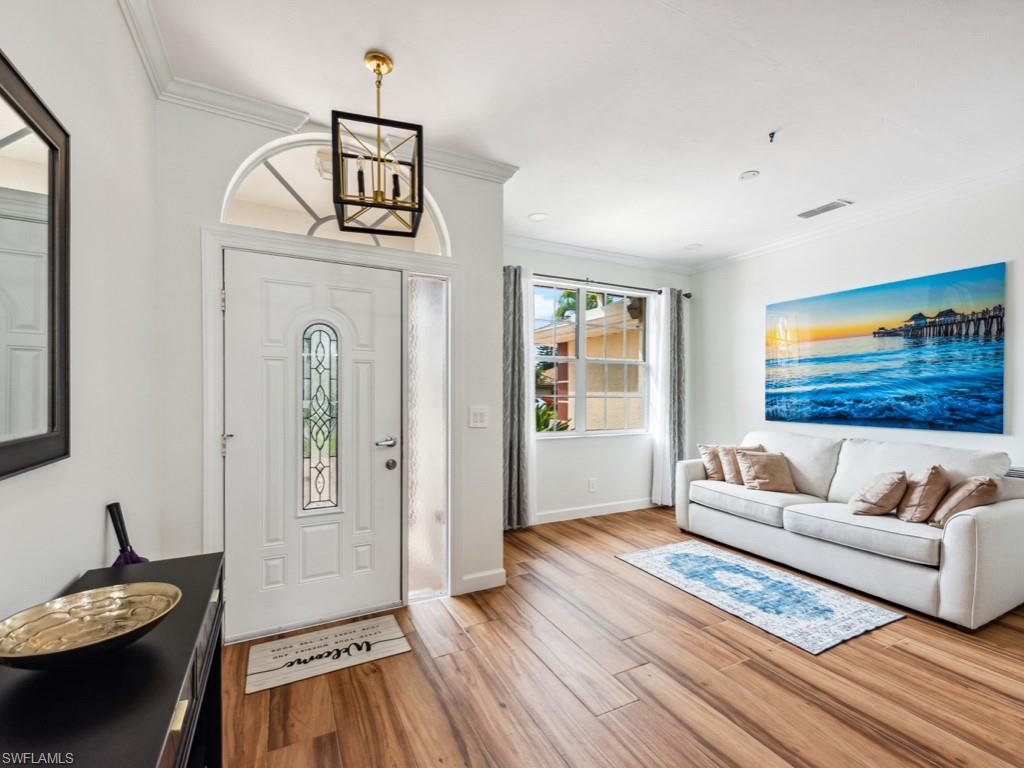 127 Palmetto Dunes Circle Naples, FL 34113 - Photo 13 of 20 a living room with furniture and a wooden floor