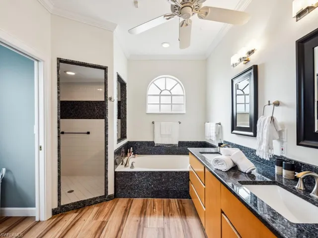 a spacious bathroom with a granite countertop sink mirror and a bathtub