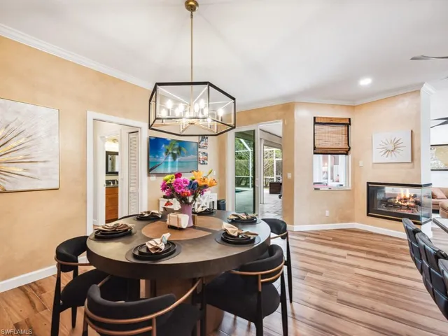 a view of a dining room with furniture a chandelier and wooden floor
