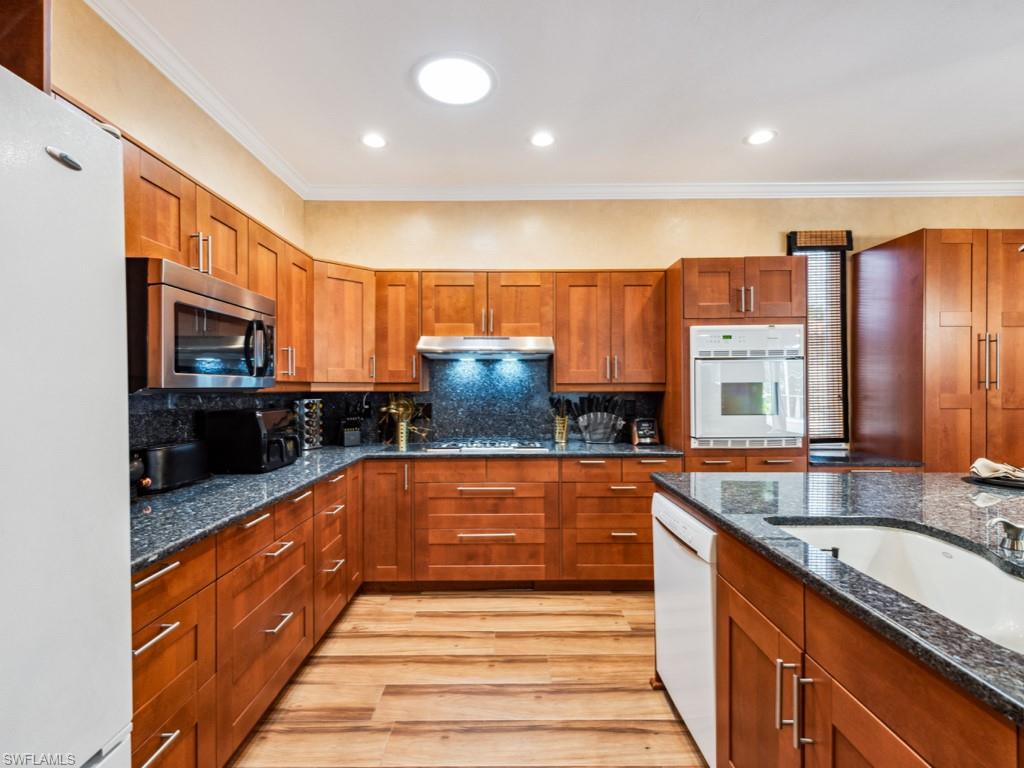 127 Palmetto Dunes Circle Naples, FL 34113 - Photo 8 of 20 a large kitchen with stainless steel appliances granite countertop a sink and cabinets
