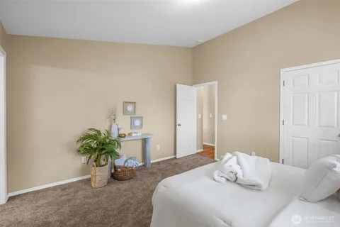 a bedroom with a bed table and a potted plant