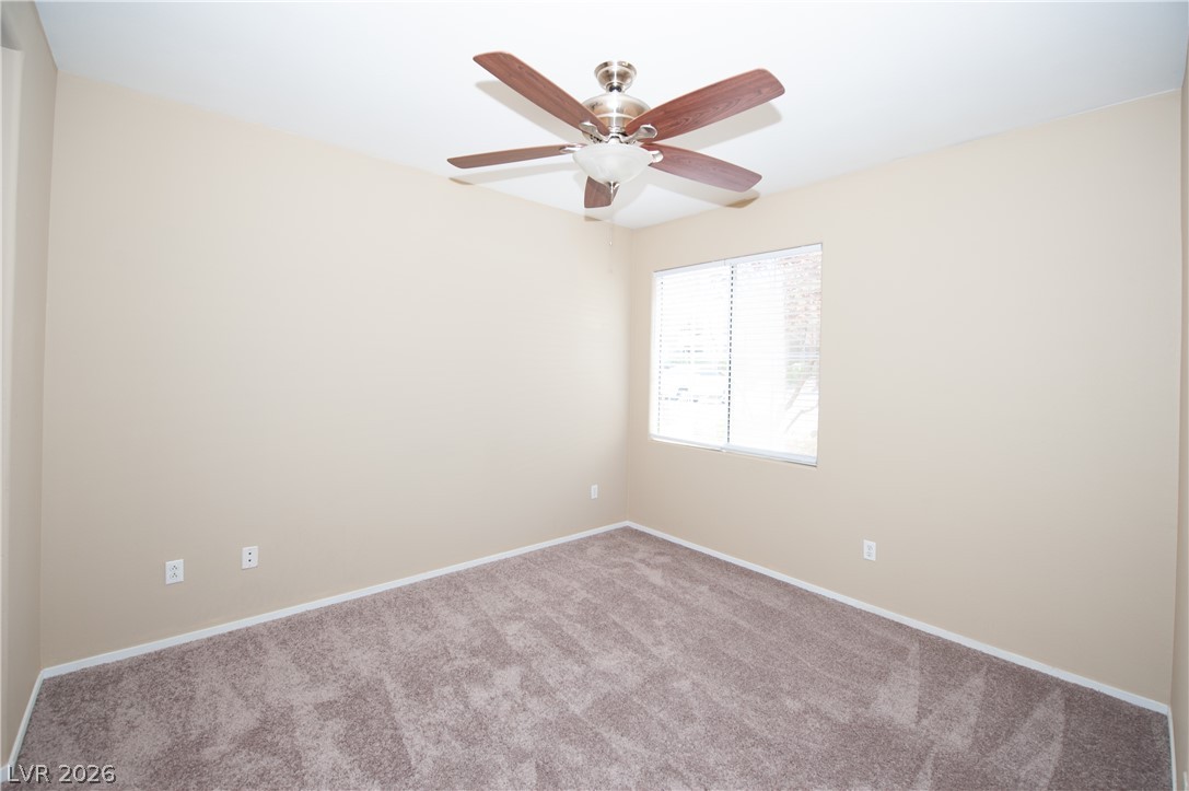 9050 West Warm Springs Road, Unit 1132 Las Vegas, NV 89148 - Photo 12 of 21 A well-lit room featuring a window and a ceiling fan, offering a comfortable atmosphere.