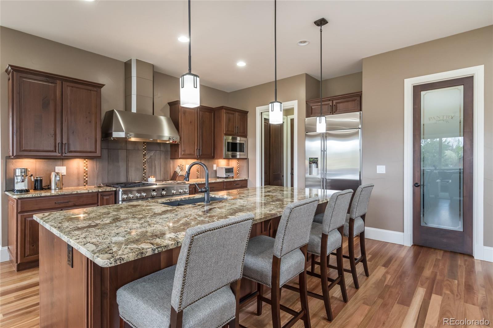 4624 Sunnyside Place Boulder, CO 80301 - Photo 5 of 40 a kitchen with stainless steel appliances granite countertop a kitchen island a table and chairs in it