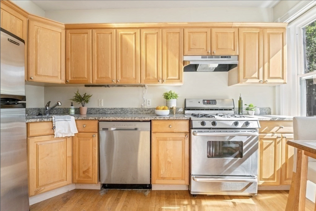 120 Brook Street, Unit 3 Brookline, MA 02445 - Photo 2 of 10 a kitchen with stainless steel appliances granite countertop a stove a sink and white cabinets with wooden floor
