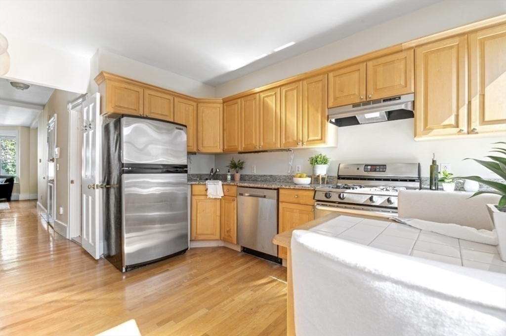 120 Brook Street, Unit 3 Brookline, MA 02445 - Photo 4 of 10 a kitchen with granite countertop a refrigerator and a stove top oven