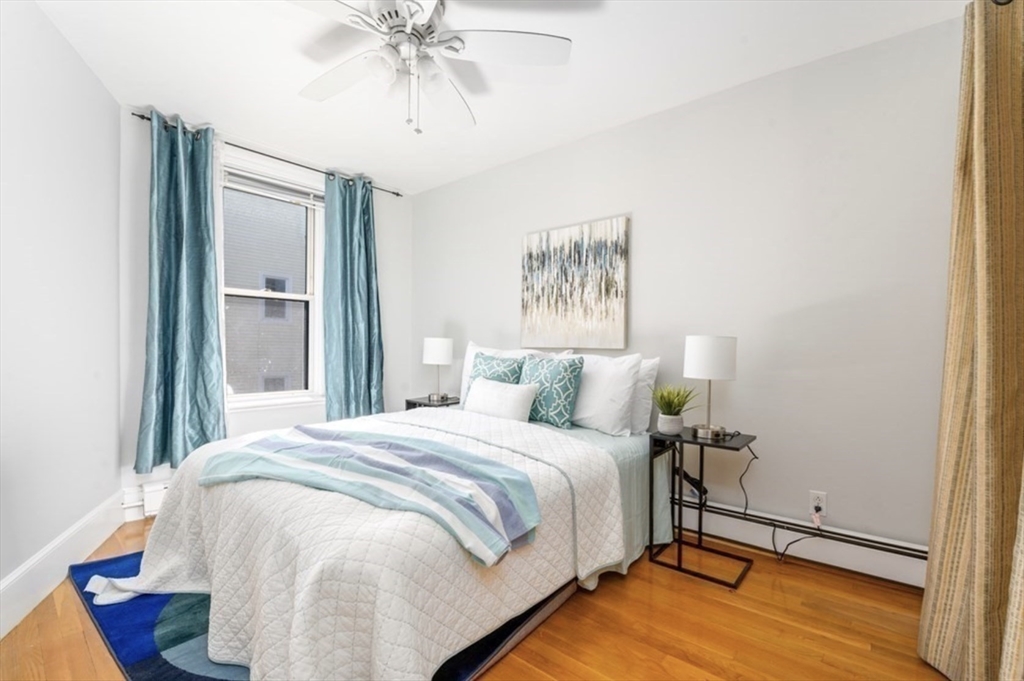 120 Brook Street, Unit 3 Brookline, MA 02445 - Photo 8 of 10 a bedroom with a bed and a chandelier