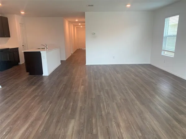 a view of a livingroom with wooden floor and windows
