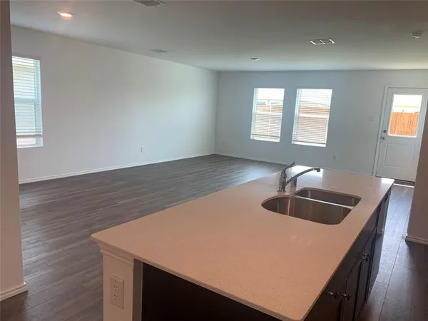 a kitchen with kitchen island a sink and wooden floor