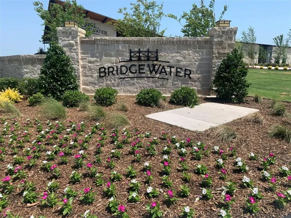 a sign that is sitting in front of flowers