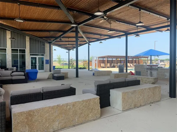 a view of a patio with couches and table under an umbrella