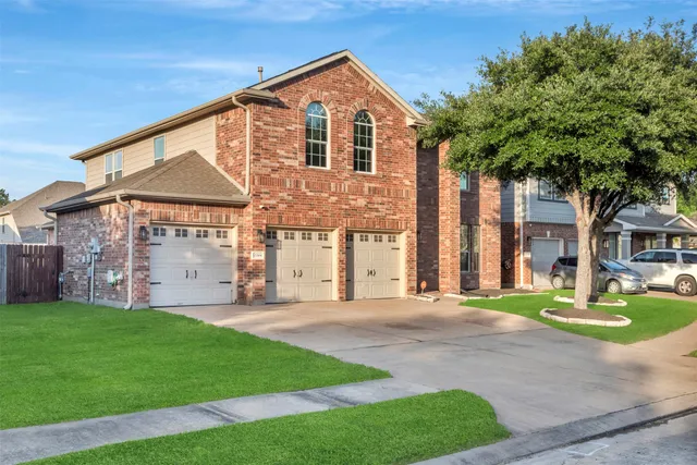 a front view of a house with a yard and trees