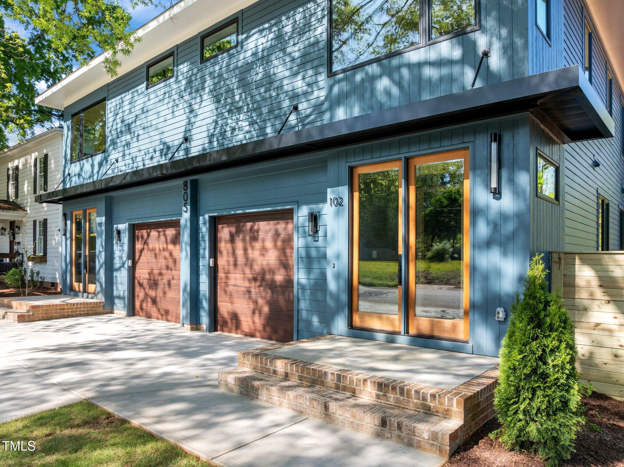805 Tower Street, Unit 102 Raleigh, NC 27607 - Photo 1 of 36 a view of a house with large windows and plants