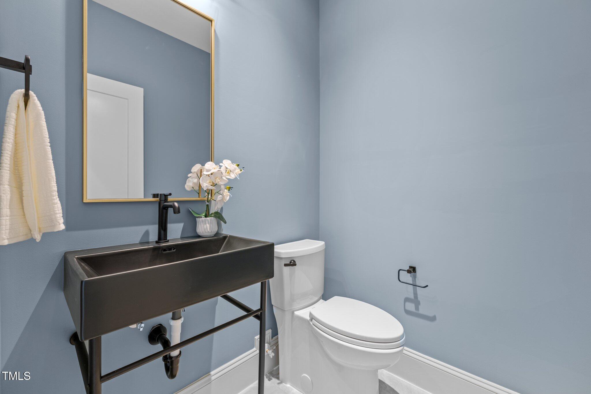 805 Tower Street, Unit 102 Raleigh, NC 27607 - Photo 14 of 36 a bathroom with a toilet a sink and mirror