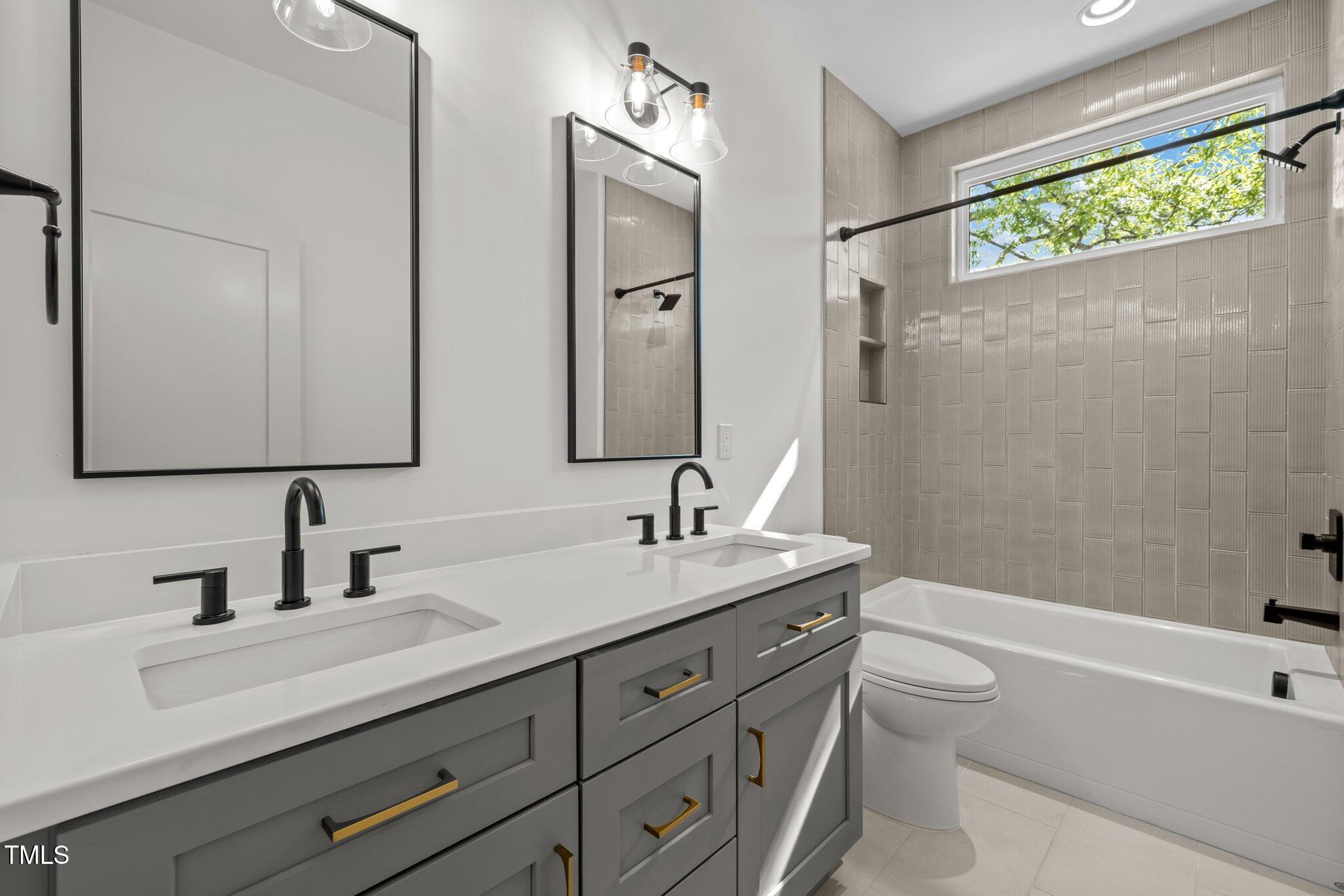 805 Tower Street, Unit 102 Raleigh, NC 27607 - Photo 23 of 36 a bathroom with a granite countertop sink a toilet a mirror and shower