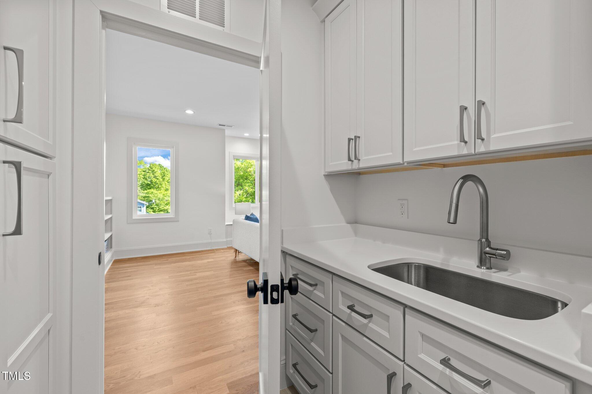 805 Tower Street, Unit 102 Raleigh, NC 27607 - Photo 30 of 36 a kitchen with a sink and cabinets