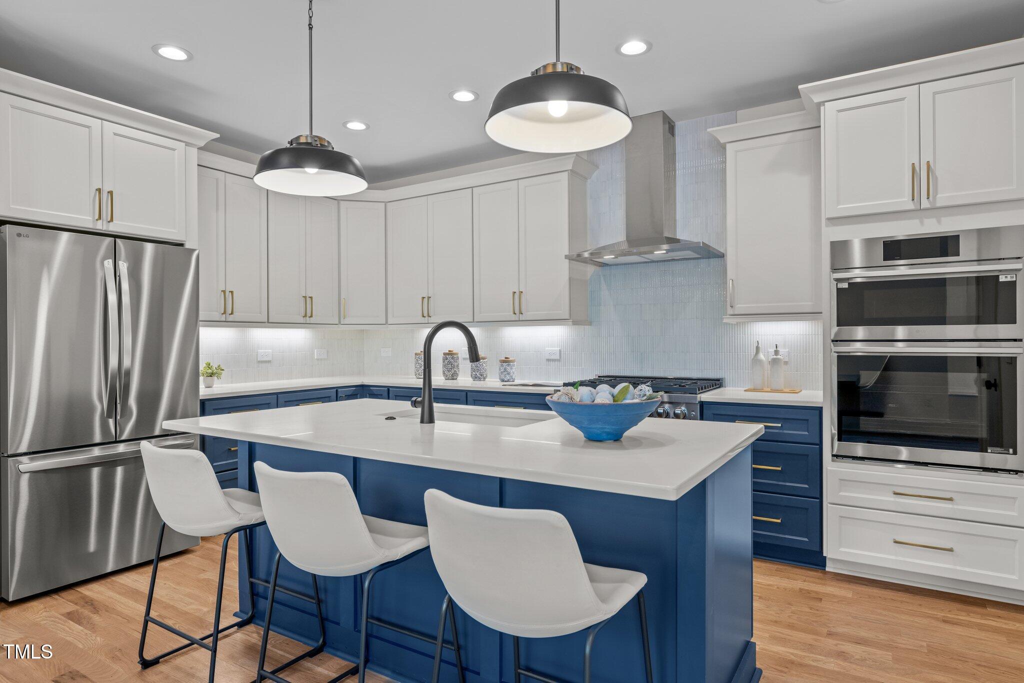 805 Tower Street, Unit 102 Raleigh, NC 27607 - Photo 5 of 36 a kitchen with stainless steel appliances granite countertop a sink a stove a refrigerator cabinets and chairs