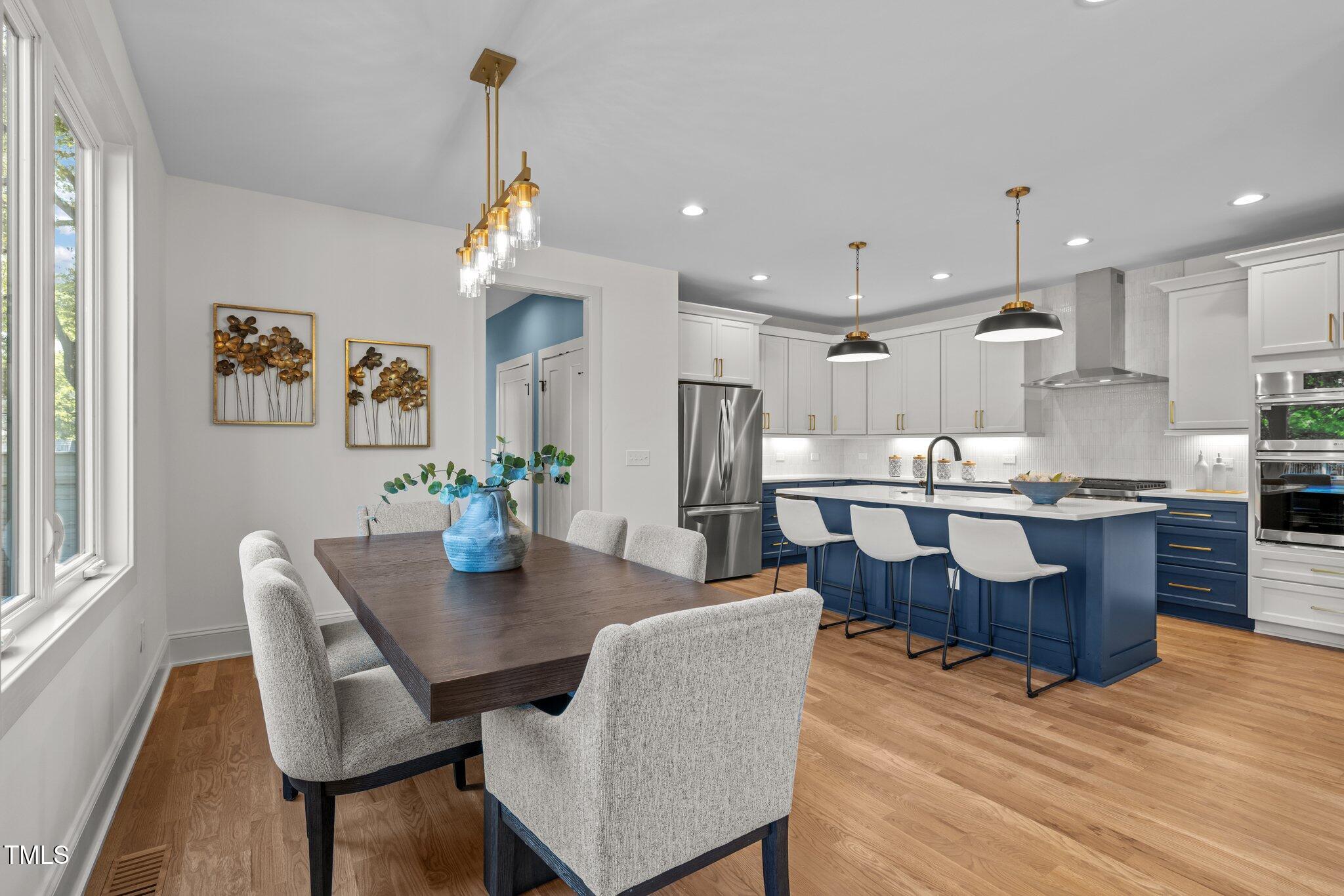 805 Tower Street, Unit 102 Raleigh, NC 27607 - Photo 6 of 36 a kitchen with a dining table chairs stainless steel appliances and cabinets