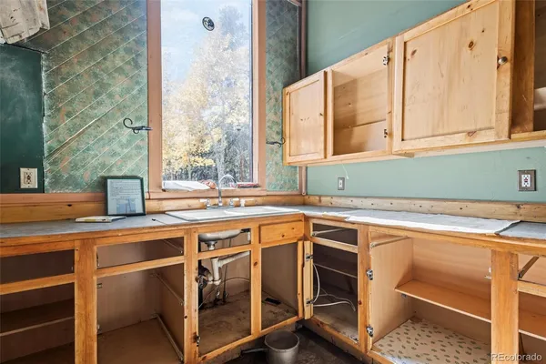 a view of an empty room with furniture and a window