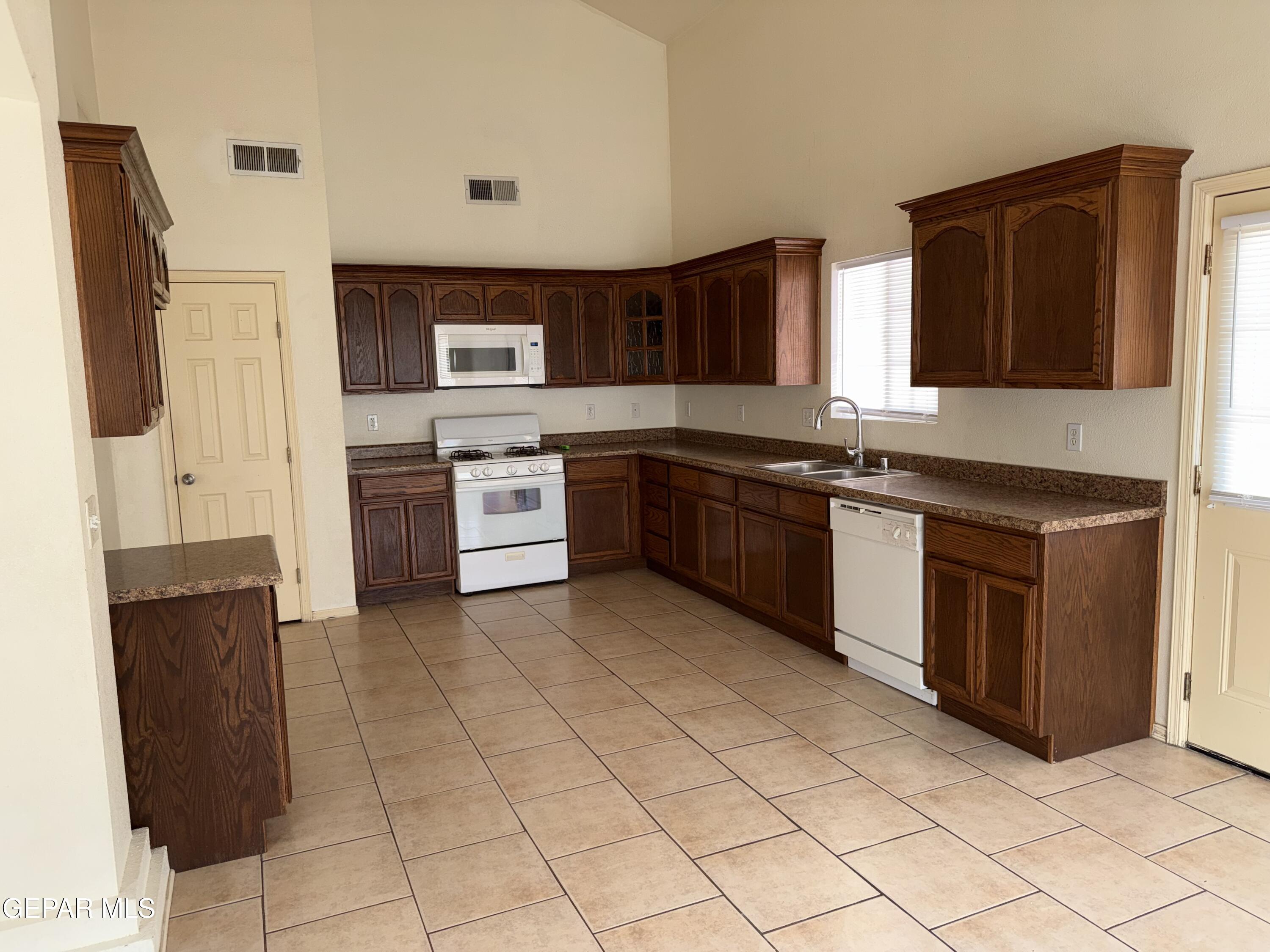 456 Passmore Road Socorro, TX 79927 - Photo 6 of 23 a kitchen with stainless steel appliances granite countertop a sink and stove top oven