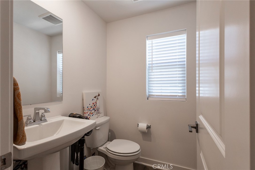 2640 Sprout Lane, Unit 104 Corona, CA 92883 - Photo 6 of 20 a bathroom with a sink a toilet and a mirror