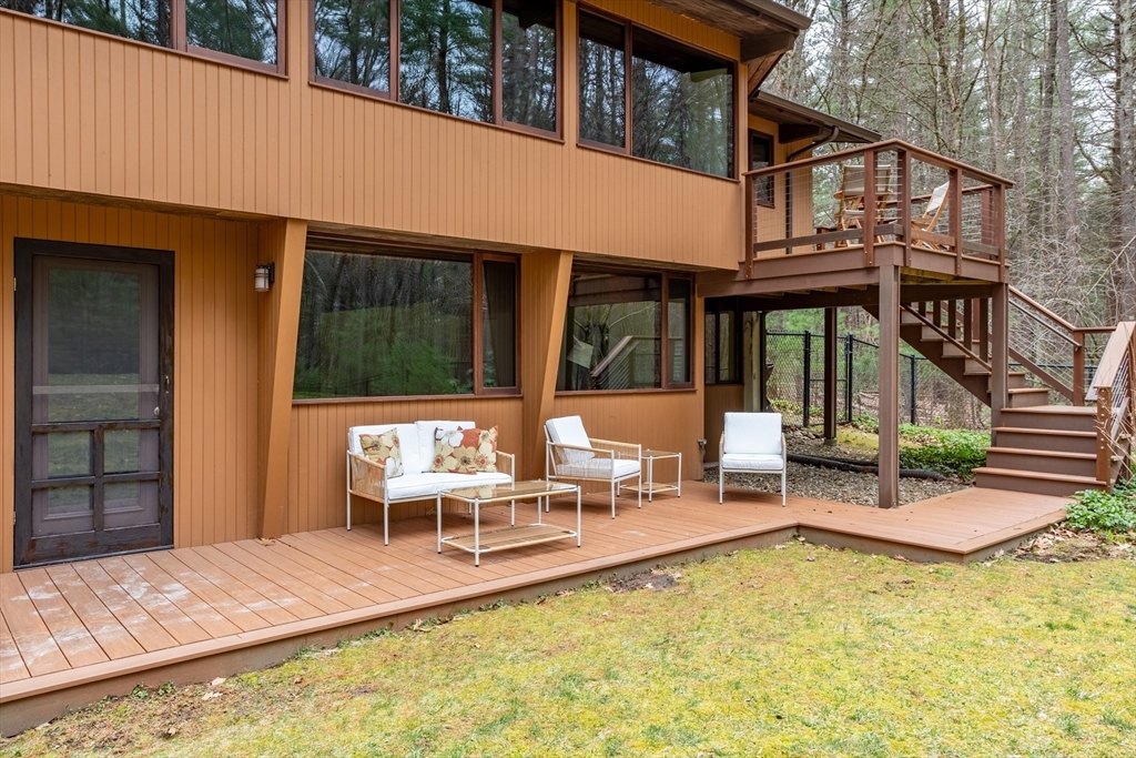 69 Long Ridge Road Carlisle, MA 01741 - Photo 39 of 42 a view of a patio with table and chairs and wooden fence