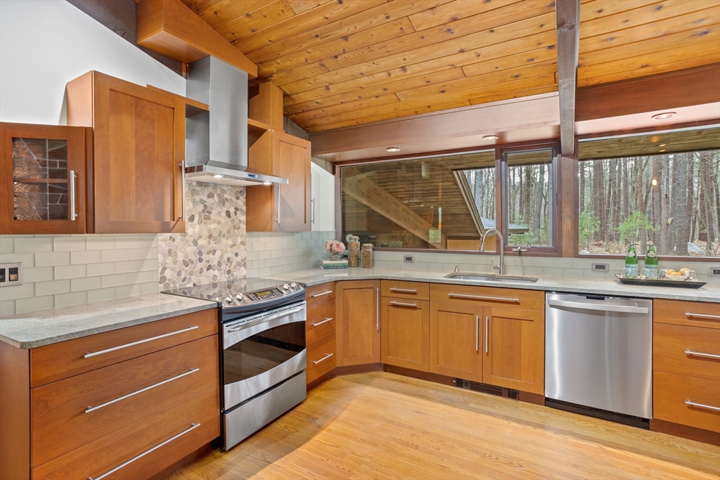 69 Long Ridge Road Carlisle, MA 01741 - Photo 8 of 42 a kitchen with stainless steel appliances granite countertop a sink and cabinets