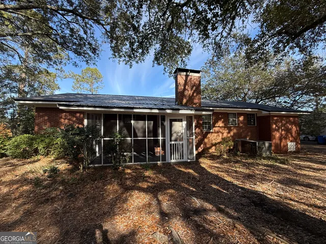 a view of a house with backyard and sitting area