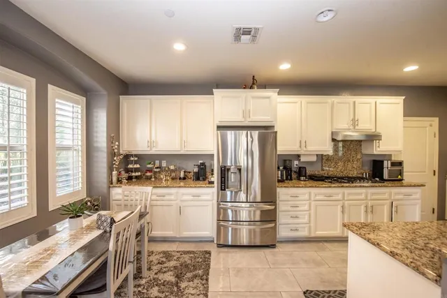 a bedroom with a large bed a flat tv screen and dresser
