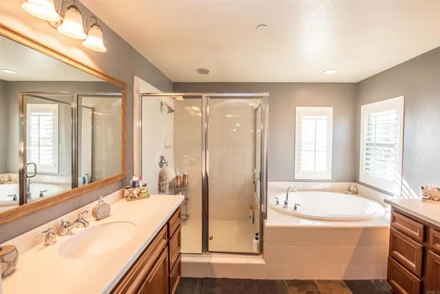 a view of a livingroom with a chandelier fan and wooden floor