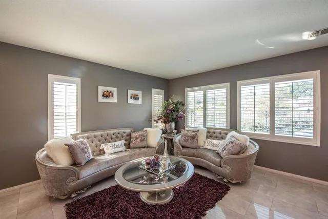 a living room with furniture wooden floor and a large window
