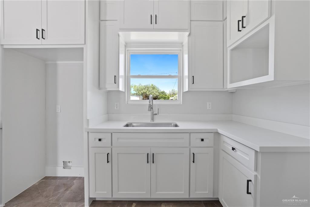 1003 Short Road San Juan, TX 78589 - Photo 14 of 20 a kitchen with white cabinets and a sink