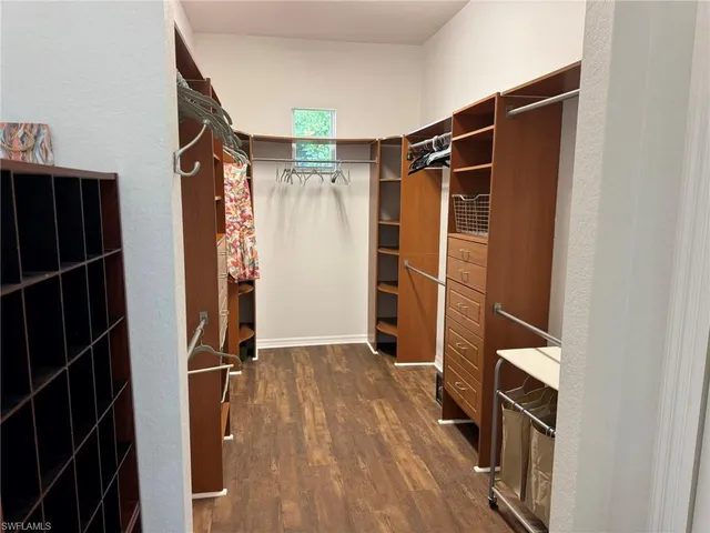 a view of walk in closet with clothes and shoes