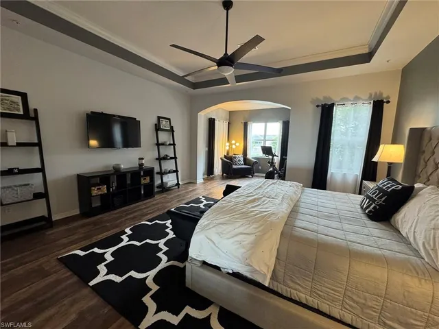 a bedroom with a bed and a flat tv screen on dresser