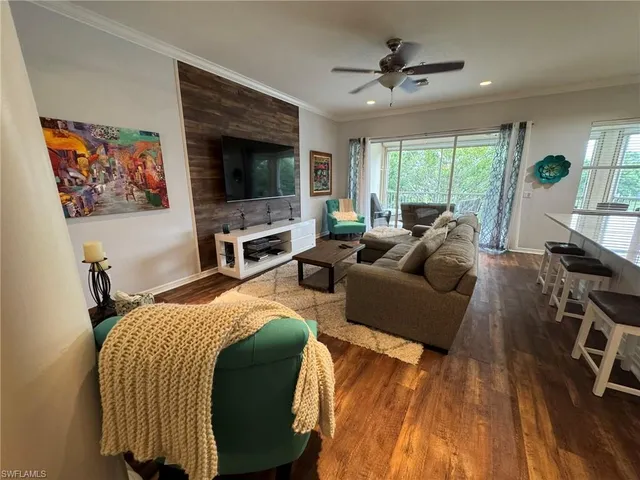 a bedroom with a bed a flat screen tv and a large window