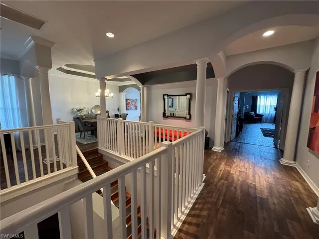 a view of a hallway with wooden floor and stairs