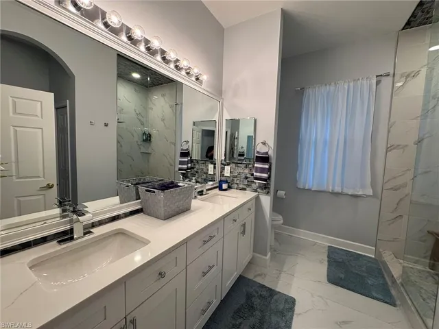 a bathroom with double vanity and a mirror