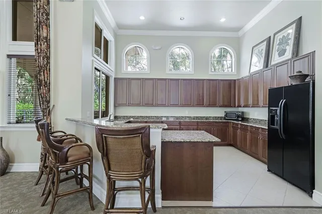 a kitchen with stainless steel appliances granite countertop a table chairs in it and wooden floors