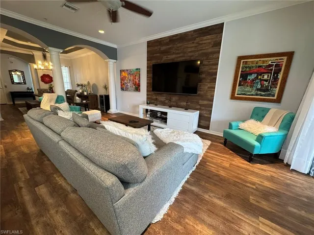 a living room with furniture a flat screen tv and a fireplace