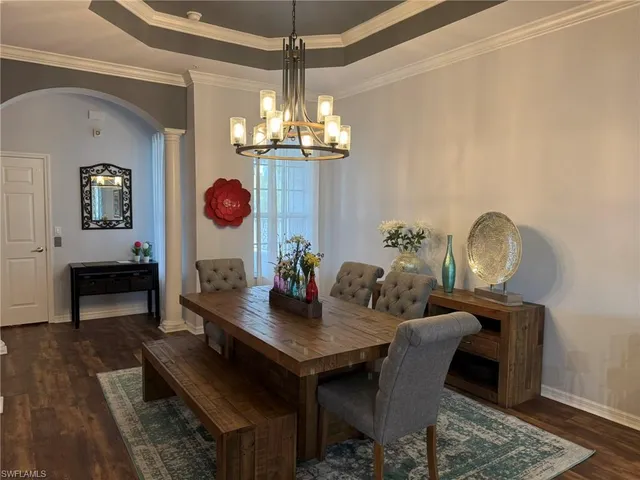 a view of a dining room with furniture a chandelier and wooden floor