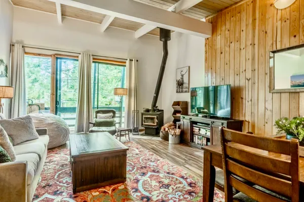 a living room with furniture large window and wooden floor