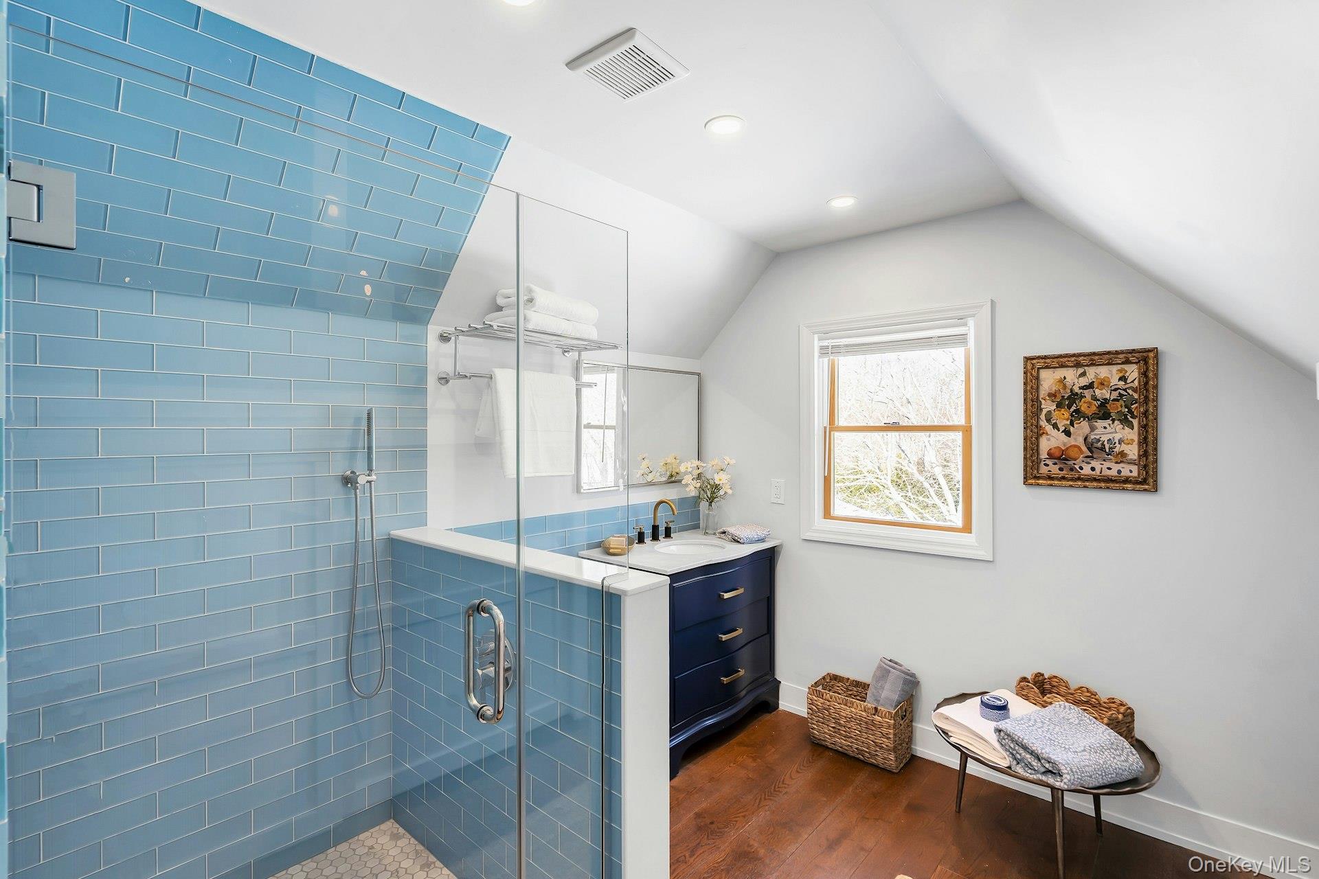 235 Cemetery Road East Marion, NY 11939 - Photo 25 of 37 Ensuite spa like bathroom with blue glass tile, toilet and vanity. Window view to backyard.