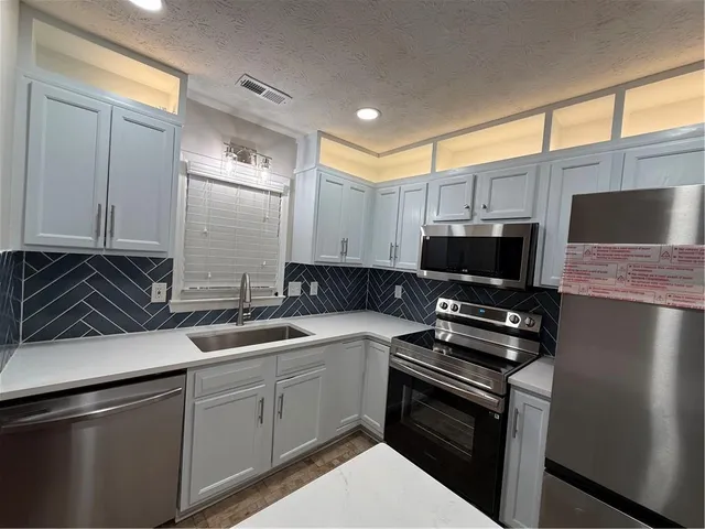 a kitchen that has a sink and a stove top oven