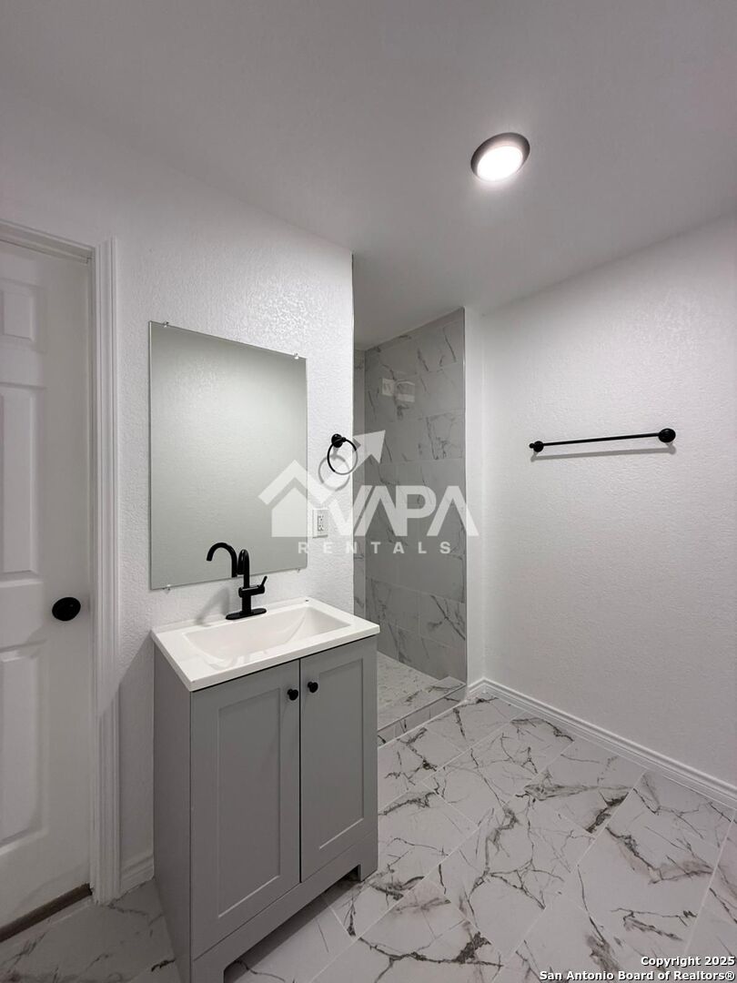 7422 Pipe Spring Street San Antonio, TX 78238 - Photo 12 of 13 a bathroom with a sink toilet and mirror