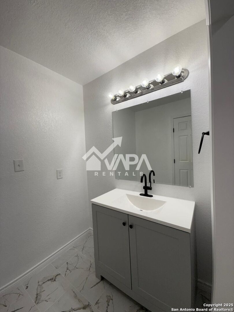 7422 Pipe Spring Street San Antonio, TX 78238 - Photo 5 of 13 a bathroom with a sink a mirror and vanity
